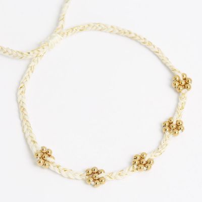 Bracelet cordon blanc et lurex dore avec marguerite en perles d'acier